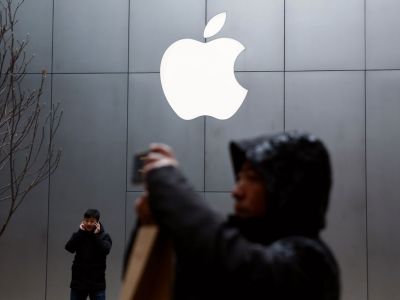 Люди используют свои телефоны возле магазина Apple в Пекине, Китай, 7 января 2019. Фото: Thomas Peter / Reuters