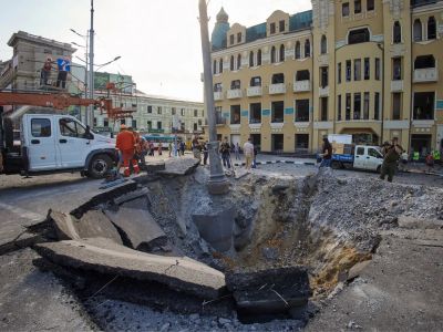 Коммунальщики работают на месте попадания российской ракеты в центре Харькова. Фото: Sergey Kozlov / EPA